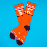 Orange socks with 'Bite Me' text on a blue background