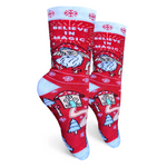 Red Christmas-themed socks with Santa Claus and 'Believe in Magic' text on a white background
