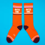 Orange socks with 'BITE ME' text on a blue background