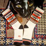 Vintage Cat sculpture ovrlooking 'Horny for Thrift Stores' socks on a patterned rug