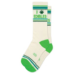 A pair of white gym socks with green stripes and text that reads 'I (Pot Leaf) Edibles'.