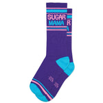 A pair of purple crew socks with 'SUGAR MAMA' written in white and pink stripes, and pink accents on the heel and toe.