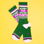Green socks with text ' Horny for house plants' on a yellow background