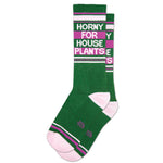 A pair of green socks with pink cuffs and text that reads 'Horny For House Plants' in a bold font.