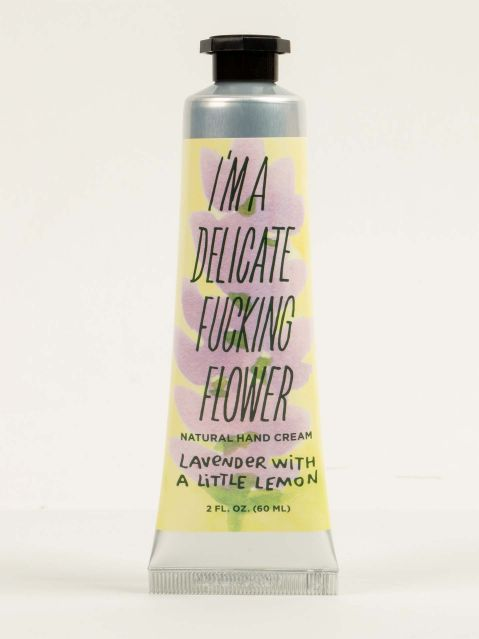 3 oz tube of lotion with an yellow and purple floral print of lavendar flowers on the front. The words "I'm a delicate fucking flower" on the front.