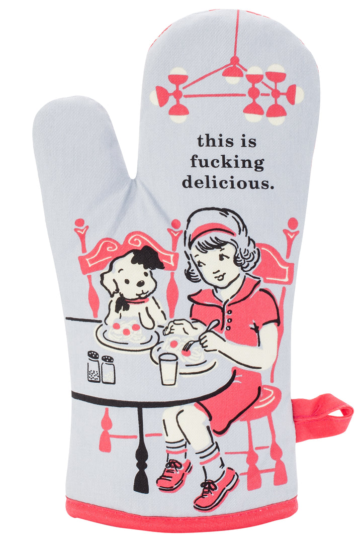 Blue Q oven mitt. A grey background with a pink and black illustration of a girl sitting at a table and eating with her dog. Above them it reads "This is fucking delicious"