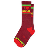 A pair of red and yellow crew socks with 'I ❤️ KIMCHI' text and heart symbol in green.