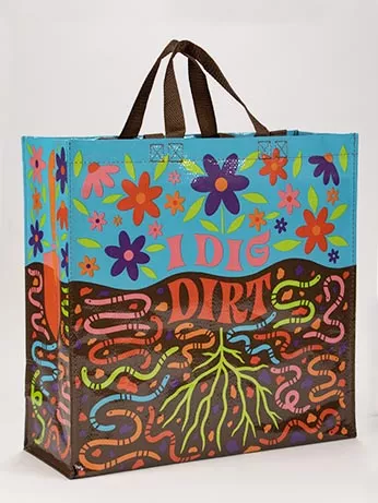 Blue Q's large shopping tote made of 95% recycled materials. The top half is blue and full of red, pink and purple flowers. Brown fabric straps for easy carrying. The bottom half is brown containing roots and pink, red, blue and green earthworms. In the middle in pink and red text reads "I Dig Dirt"