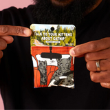 Person holding a package of organic catnip with cartoon cats on a black background