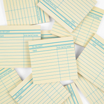 Stack of yellow lined notepads with blue lines on a white background