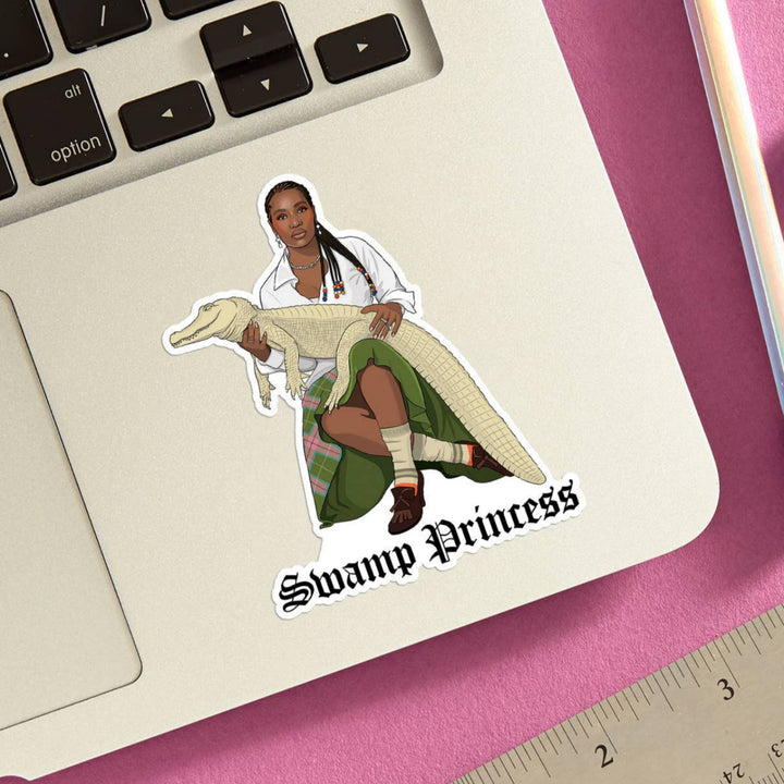 Sticker of Doechii holding an alligator with 'Swamp Princess' text on a laptop.