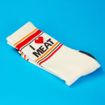 White sock with 'I ❤️ MEAT' text on a blue background