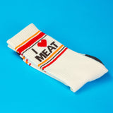 White sock with 'I ❤️ MEAT' text on a blue background