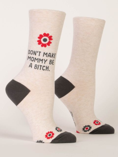 Blue Q funny socks. Cream with a dark grey toe and heel. red and grey flowers border the toe and one large red flower sits near the top of the sock above text that reads "Don't make mommy be a bitch" 