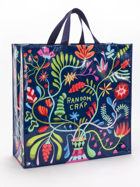 Blue Q large shopper tote made of recycled material. Navy blue with a green, yellow, pink , blue and red floral pattern. In the middle in green writing it reads "Random Crap"