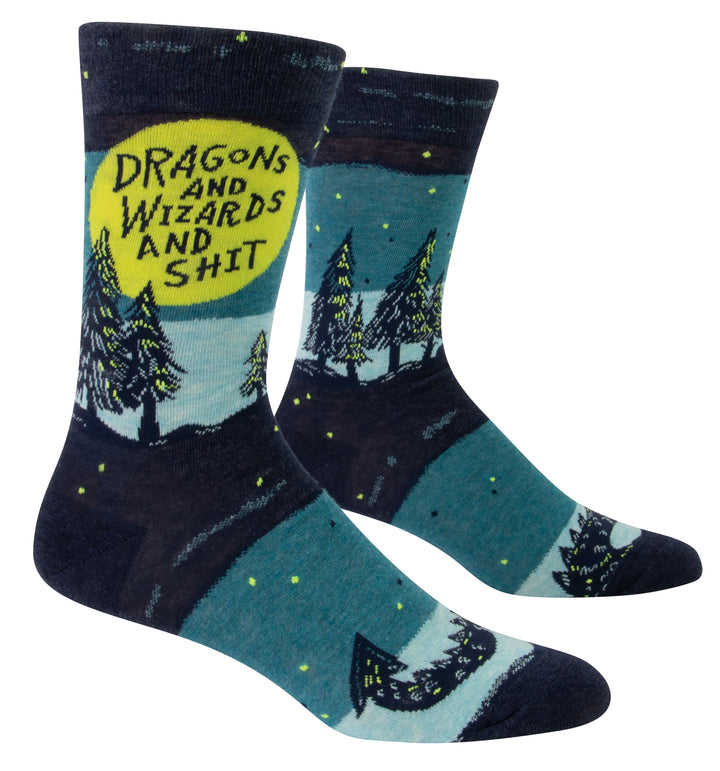 Blue Q Men's Crew socks. A night landscape illustrated with various shades of blue, pine trees with green accents line the horizon with green starts behind them. A large green circle appears as the moon and in it text reads "Dragons and Wizards and Shit"