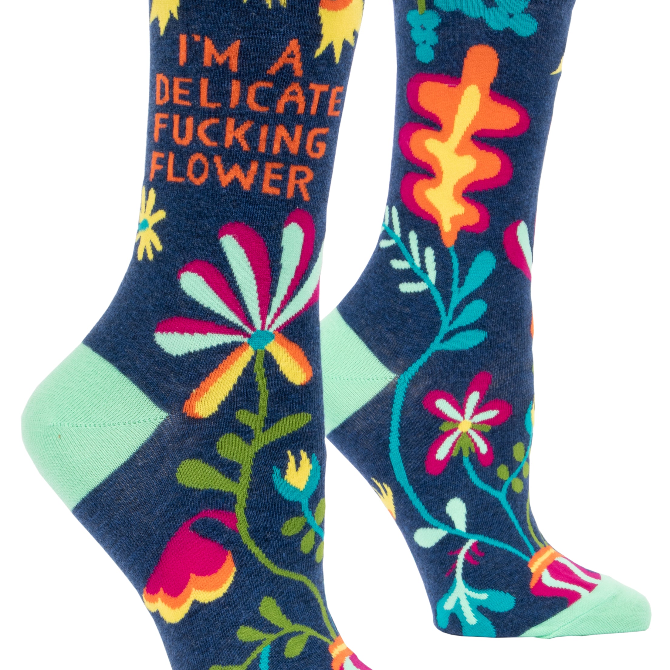 Blue Q crew socks. Navy blue with a green, yellow, blue and pink floral pattern. In orange text it reads "I'm a delicate fucking flower"