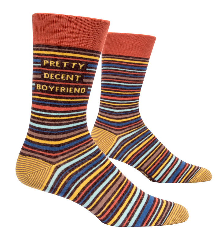 Blue Q Crew socks. A thick band of orange on the top and yellow heel and toe color blocks. The socks are covered in yellow, brown, orange and blue horizontal stripes. Under the orange color block in yellow letters reads "Pretty Decent Boyfriend"