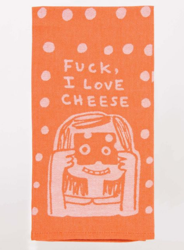 Blue Q dish towel. Orange with white polka dots, at the bottom a girl is holding a piece of cheese up to her face and looking through the holes. Above her heads reads "Fuck, I love cheese"