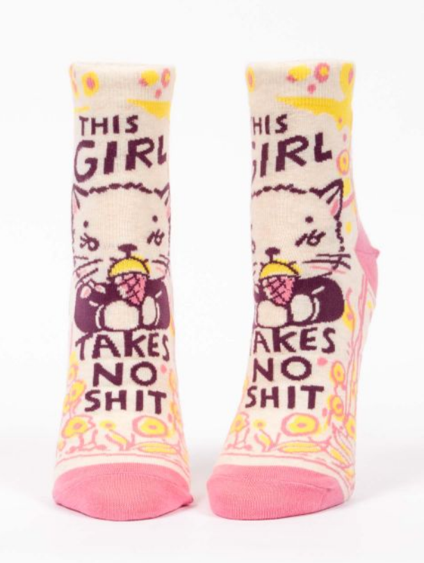 Blue Q ankle socks. Cream socks with a pink, yellow and purple illustration of a cat licking an ice cream cone. Above and below it reads "This girl takes no shit"