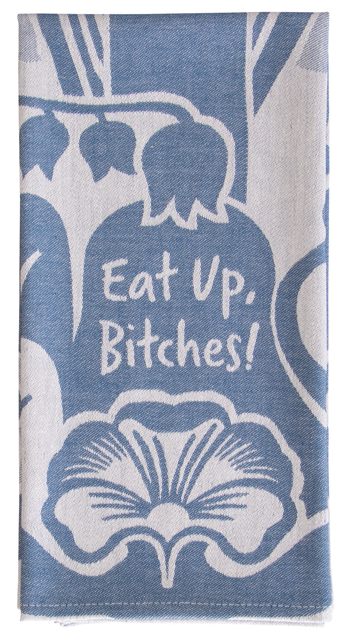 Blue Q Dish towel. A blue and grey woven towel shows a couple of flowers, in the middle the words "Eat up, bitches"