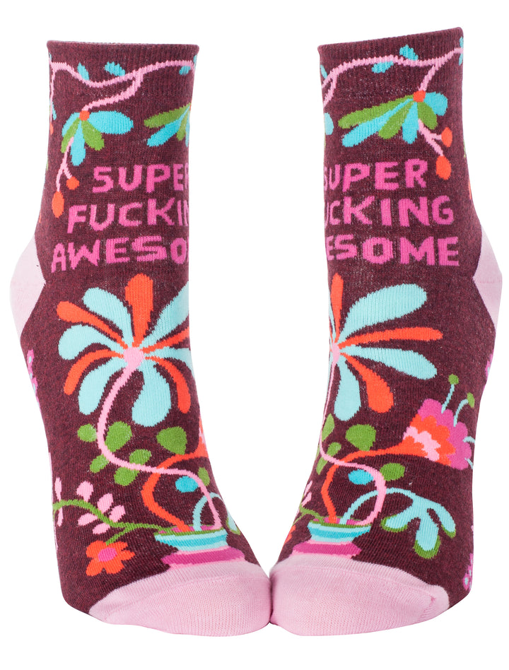 Blue Q Crew socks. Maroon with a pink, orange, green, and blue floral pattern. In pink letters on the top portion it reads "Super fucking awesome"