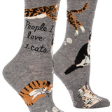 Blue Q crew socks. Grey with multiple orange, black and white cats illustrated on the sock. In the middle in black script reads "People I love: Cats."