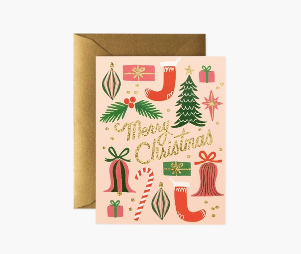 Rifle Paper Co. Christmas Card. A like pink backgroundw tih green, red and pink illustrations on the front of christmas trees, candy canes, oranments, holly, stars, bells and presents. In the middle in gold glitter script it says "Merry Christmas"